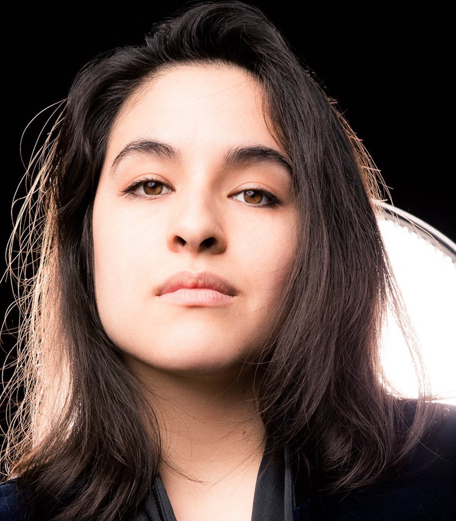 A headshot of Christina Casano, a woman with medium length brown hair, over a black and white background