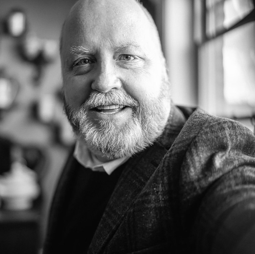A black and white image of Nick Bowling, a bald middle-aged white man with a beard